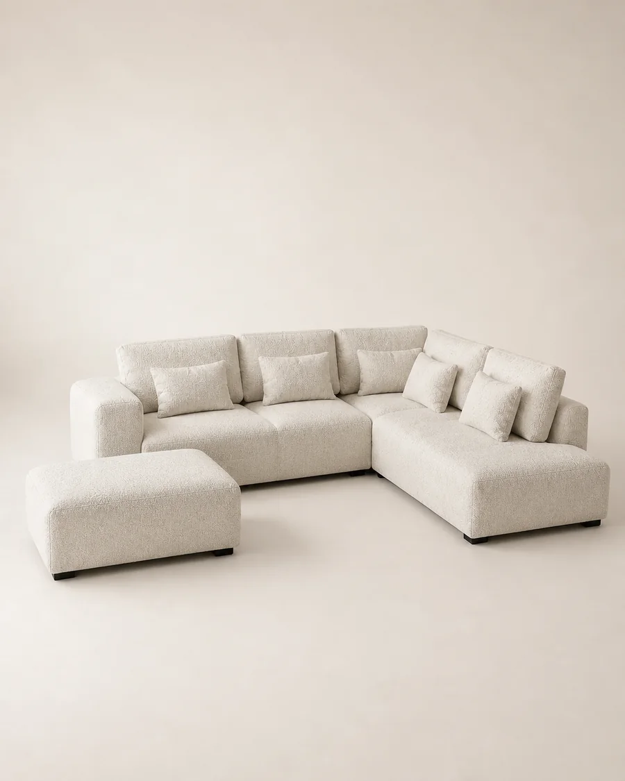 Configured warm white modular sofa and ottoman on a studio background